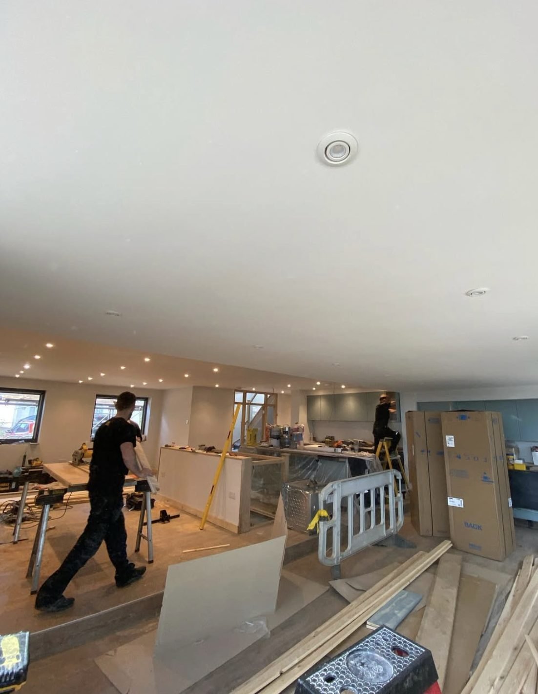 Recessed downlights across a newly plastered open-plan ceiling