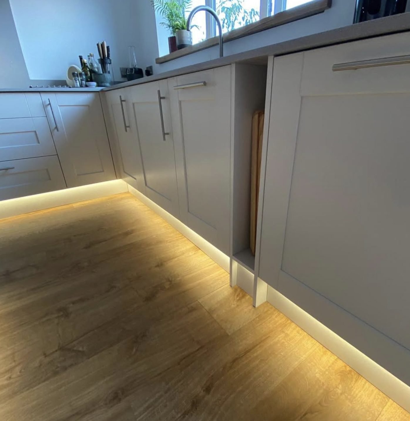 Warm LED plinth lighting installed the length of a Sheffield kitchen
