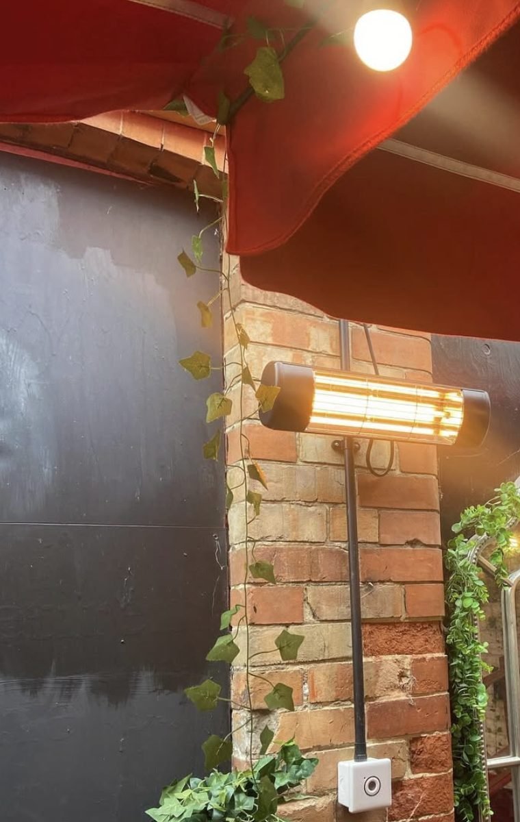 Infrared patio heater fixed to brickwork under an awning